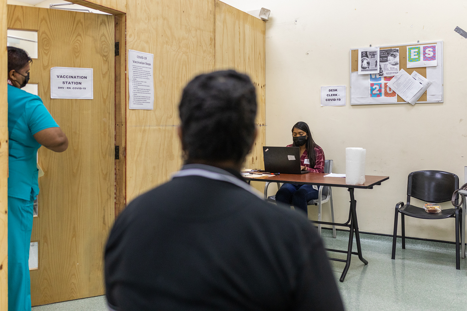 During a simulation exercise on 6 March 2021, people acting as COVID-19 vaccine recipients wait to be registered.