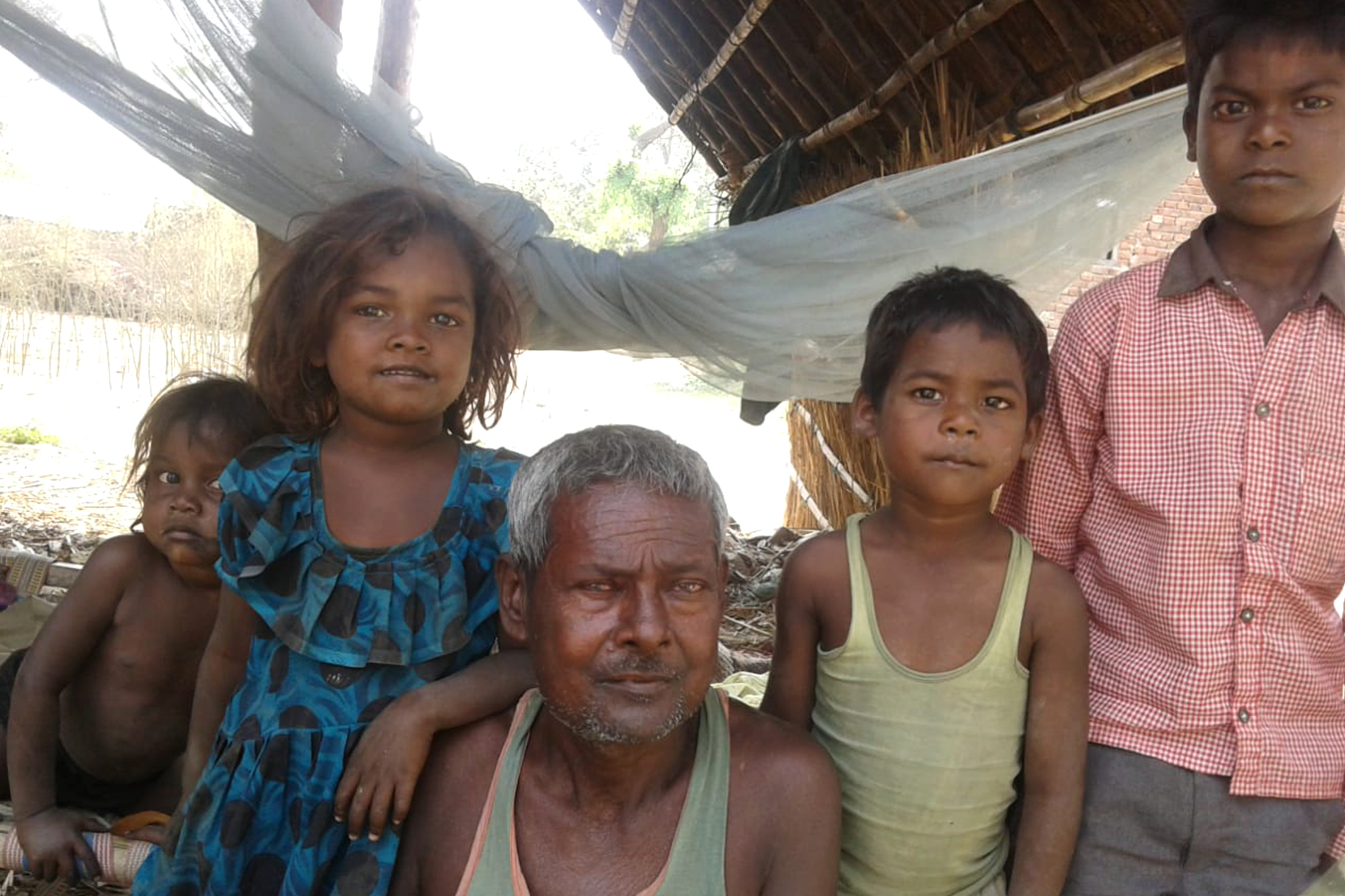 A treated kala-azar man, posing with grandchildren.