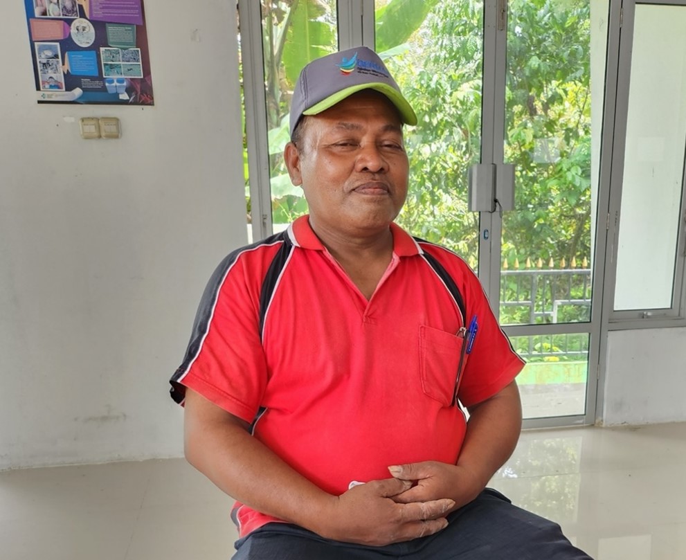 Berling Lago, a man in red shirt, sitting on a chair.
