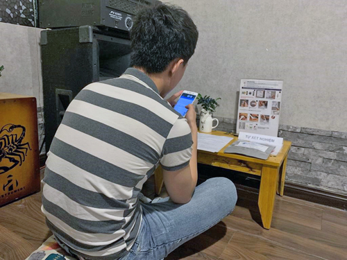 A man in Viet Nam reviewing instructions to perform HIV self-test